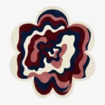An overhead studio shot of a flower-shaped Bloom Wave area rug featuring wavy concentric layers of navy, burgundy, and cream.