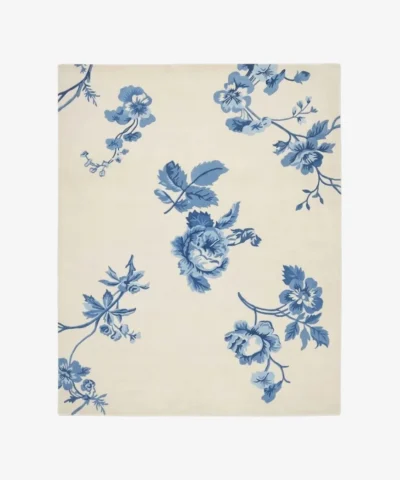 Full top-down isolated product shot of the rectangular Bluevine Bloom area rug, featuring classic Chintz-style trailing botanical vines and rose bouquets in shades of cornflower and denim blue on a soft ivory white field.