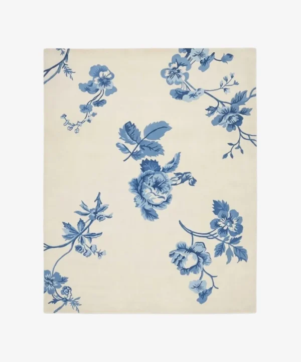 Full top-down isolated product shot of the rectangular Bluevine Bloom area rug, featuring classic Chintz-style trailing botanical vines and rose bouquets in shades of cornflower and denim blue on a soft ivory white field.