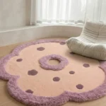 Wide-angle interior shot of the flower-shaped Camellia Bloom area rug styled on a light wood floor in a cozy room setting with a textured modern armchair.
