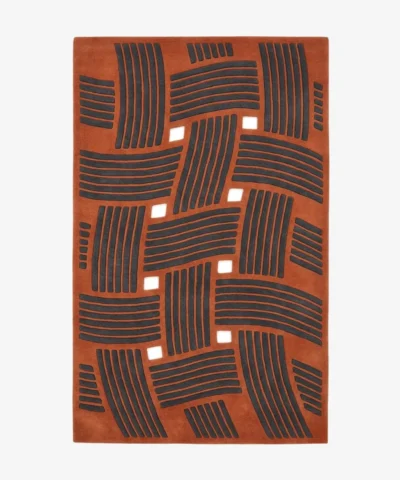 Full top-down product isolated shot of the rectangular Clay Knoty area rug, showcasing a structural basketweave design with raised charcoal grey linear blocks over a rich terracotta orange field with square geometric cutouts.