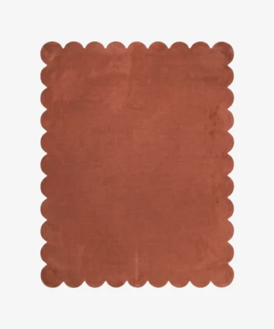 Full top-down view of the Clay Scallop rug isolated on a white background, highlighting its solid terracotta clay color and uniform wavy scalloped edges.