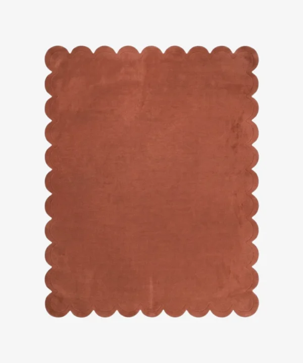 Full top-down view of the Clay Scallop rug isolated on a white background, highlighting its solid terracotta clay color and uniform wavy scalloped edges.
