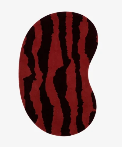 Full top-down product isolated shot of the bean-shaped Crimson Rift irregular area rug featuring a bold red base with jagged, dark burgundy abstract vertical stripes.