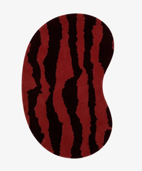 Full top-down product isolated shot of the bean-shaped Crimson Rift irregular area rug featuring a bold red base with jagged, dark burgundy abstract vertical stripes.