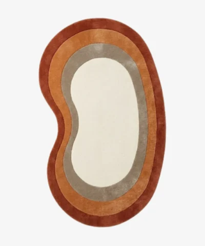 Full top-down product isolated shot of the custom kidney-bean-shaped Elio Bend accent rug, featuring concentric retro border rings in rust red, burnt orange, and taupe grey surrounding a solid ivory white center field.