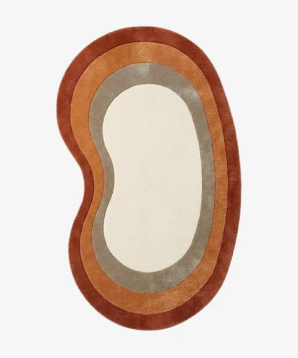 Full top-down product isolated shot of the custom kidney-bean-shaped Elio Bend accent rug, featuring concentric retro border rings in rust red, burnt orange, and taupe grey surrounding a solid ivory white center field.