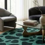 Close-up top angle perspective showcasing the vibrant solid color blocks, plush depth, and natural stone-like pattern transitions of the Fernfall green area rug.