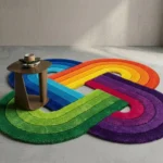 Wide perspective interior lifestyle shot of the Funfinity rainbow infinity loop rug styled on a gray concrete floor next to a modern wooden side table.