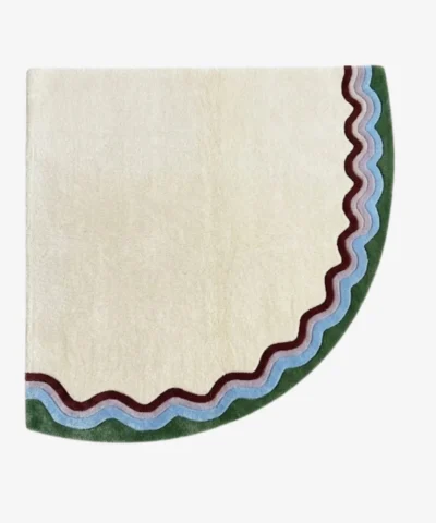 Full top-down product isolated shot of the uniquely shaped Garden Wave corner accent rug featuring a cream base with multi-colored wavy outer borders in green, purple, and burgundy tones.