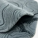 Detail photograph of the Glacier Terrain rug folded over to showcase the high-quality pile depth and intricate topographical pattern.