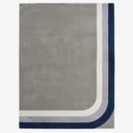 Full top-down product isolated shot of the rectangular Halo Verge area rug, featuring a large minimalist grey field bordered by retro mid-century curved corner bands in cream, lavender purple, and deep navy blue.