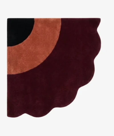 Full top-down product isolated shot of the uniquely shaped Harvest Moon scalloped corner rug featuring black, terracotta, and burgundy tones.