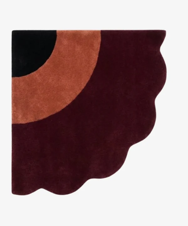 Full top-down product isolated shot of the uniquely shaped Harvest Moon scalloped corner rug featuring black, terracotta, and burgundy tones.