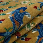 Close-up macro photograph highlighting the plush wool material texture and intricate tufting of the blue and gold Koi Pond rug.