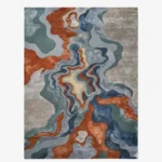 Full top-down product isolated shot of the uniquely shaped Landform Drift abstract rug, featuring fluid topographical layers in rust, blue, green, and beige.