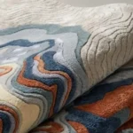 Low angle close-up floor perspective showcasing the intricate topographical lines, plush hand-tufted pile, and fluid organic design of the Landform Drift rug.