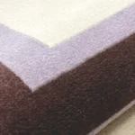 Close-up macro photograph highlighting the premium thick wool material texture and clean solid color borders of the Lilac Horizon rug.