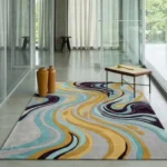 Wide perspective interior lifestyle view of the Luma River abstract wavy rug styled on a polished concrete floor in a modern, minimalist room with floor-to-ceiling glass walls.