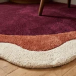 Low angle close-up perspective showcasing the plush hand-tufted pile depth and smooth wavy borders of the Lunar Arc corner rug.