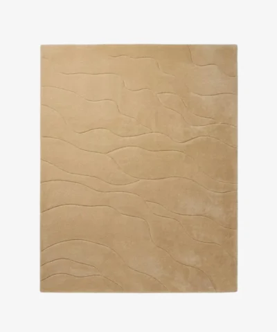 Full top-down product isolated shot of the rectangular Mira Sand area rug, featuring a subtle monochromatic design with organic wavy etched lines running across a solid warm sand beige field.