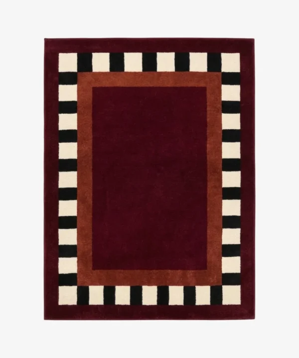 Full top-down product isolated shot of the rectangular Montero Border rug featuring a deep red center and black and white checkered border.