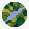 Full top-down product isolated shot of the circular Mossbrook abstract area rug featuring a multi-toned green mosaic pattern bisected by a soft blue winding river stream.