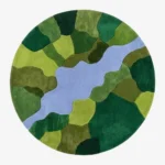 Full top-down product isolated shot of the circular Mossbrook abstract area rug featuring a multi-toned green mosaic pattern bisected by a soft blue winding river stream.
