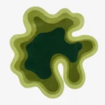 Full top-down view of the custom fluid Mosswave rug isolated on a white background, highlighting its concentric wavy design in layered blocks of lime, moss, and forest green.