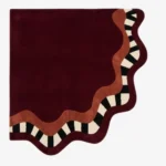 Full top-down product isolated shot of the uniquely shaped Mulberry Tide scalloped corner rug featuring a deep burgundy field with terracotta and checkered wavy borders.
