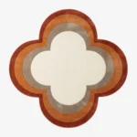 Full top-down product isolated shot of the custom quattrofoil-shaped Petra Halo area rug, featuring concentric retro border rings in rust red, burnt orange, and taupe grey surrounding a solid ivory white center field.