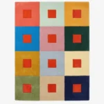 Full top-down product isolated shot of the rectangular Pixel Palette area rug featuring a geometric grid of twelve multi-colored blocks, each accented with a bold red center square.