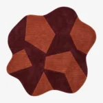 Custom-shaped fluid Prism rug isolated on a white background, featuring a fractured geometric pattern of interlocking burgundy and terracotta orange ribbed blocks.
