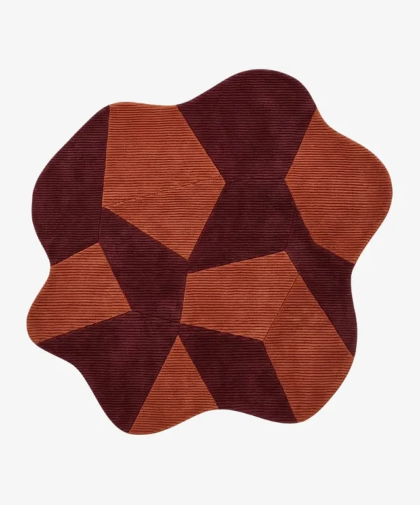 Custom-shaped fluid Prism rug isolated on a white background, featuring a fractured geometric pattern of interlocking burgundy and terracotta orange ribbed blocks.