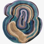 Full top-down product isolated shot of the uniquely shaped Reverb abstract rug featuring organic flowing layers in tones of teal, lavender, brown, and beige.