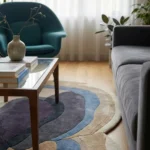 Low angle close-up floor perspective showcasing the plush hand-tufted pile and intricate layered design of the Sediment organic area rug.