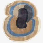 Full top-down product isolated shot of the uniquely shaped Sediment abstract rug featuring organic fluid layers in shades of beige, blue, and deep purple.