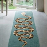 Low angle perspective shot showing the teal Serpent Runner rug displayed in a bright modern home entryway.