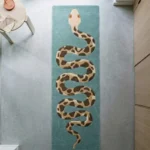 High-angle interior shot of the Serpent Runner rug styled on a gray concrete floor next to a modern side table.