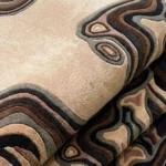 Close-up macro photograph highlighting the premium wool material texture and dense multi-level pile construction of the folded Shadow Canyon area rug.