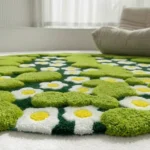 Wide perspective interior lifestyle shot of the round green Terrain Bloom rug styled in a bright, modern room next to a plush white lounge chair.