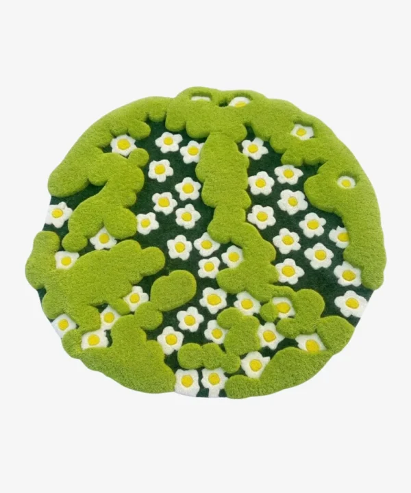Full top-down product isolated shot of the round, irregularly shaped Terrain Bloom rug featuring 3D moss green tufted borders over a daisy floral pattern.