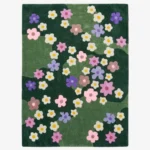 Full top-down product isolated shot of the rectangular Wildflower Meadow area rug featuring a multi-toned green field adorned with scattered retro flower motifs in pink, purple, brown, and cream.
