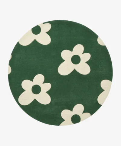 Full top-down product isolated shot of the round Floreo area rug, showcasing a playful retro pop art daisy motif with off-white flowers scattered across a vibrant forest green field.