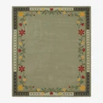 An overhead top-down view of the rectangular Florivert area rug, displaying its solid sage green center surrounded by a vibrant floral vine and a dark dashed outer edge.
