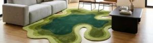 Interior lifestyle view of a large, irregular shaped area rug featuring organic, wavy topographic patterns in varying shades of forest and lime green, styled on light hardwood floors in a modern living room setting with a grey sofa and black coffee table.