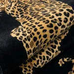 Close-up of the plush tufted pile texture and detailed leopard print of the Leobra rug.