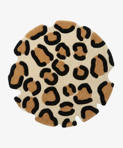 Full top-down product isolated shot of the round Leora area rug, featuring an organic, hand-carved wavy perimeter and a classic animal rosette pattern with camel brown and black leopard spots on an off-white background field.