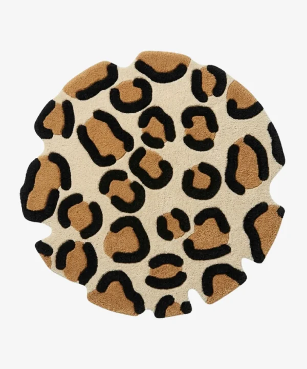 Full top-down product isolated shot of the round Leora area rug, featuring an organic, hand-carved wavy perimeter and a classic animal rosette pattern with camel brown and black leopard spots on an off-white background field.