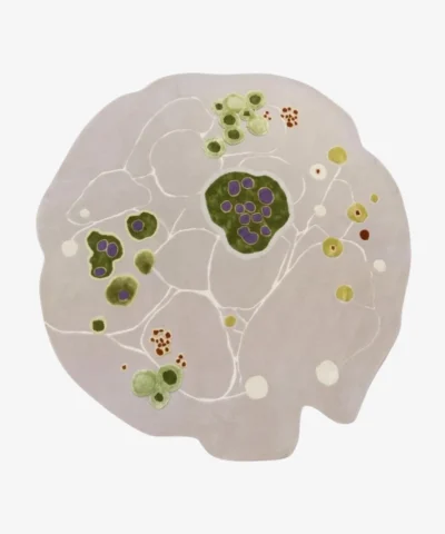 A top-down product shot of the Liora Moss area rug, featuring an irregular organic shape with a light grey base and vibrant green and purple cell-like motifs.